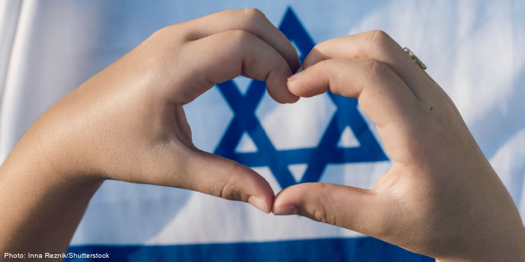 Hands in the shape of a heart in front of an Israel flag