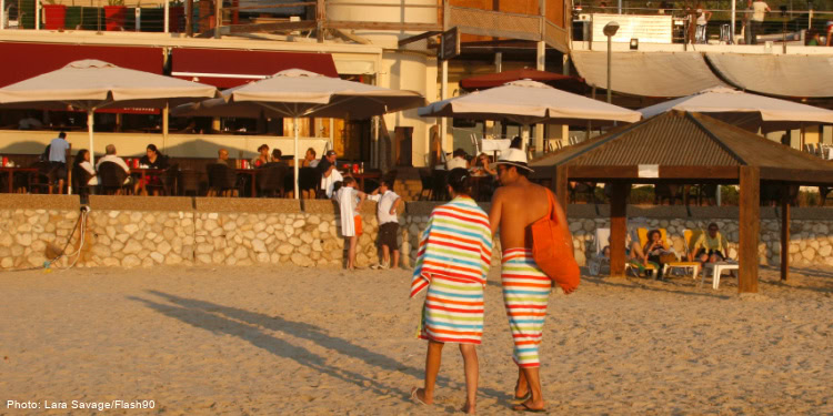 A couple walk along Herzliya beach