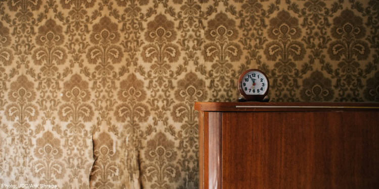 Warm, cozy room with vintage wallpaper and wooden furniture, emphasizing the importance of a supportive home environment for vulnerable families.