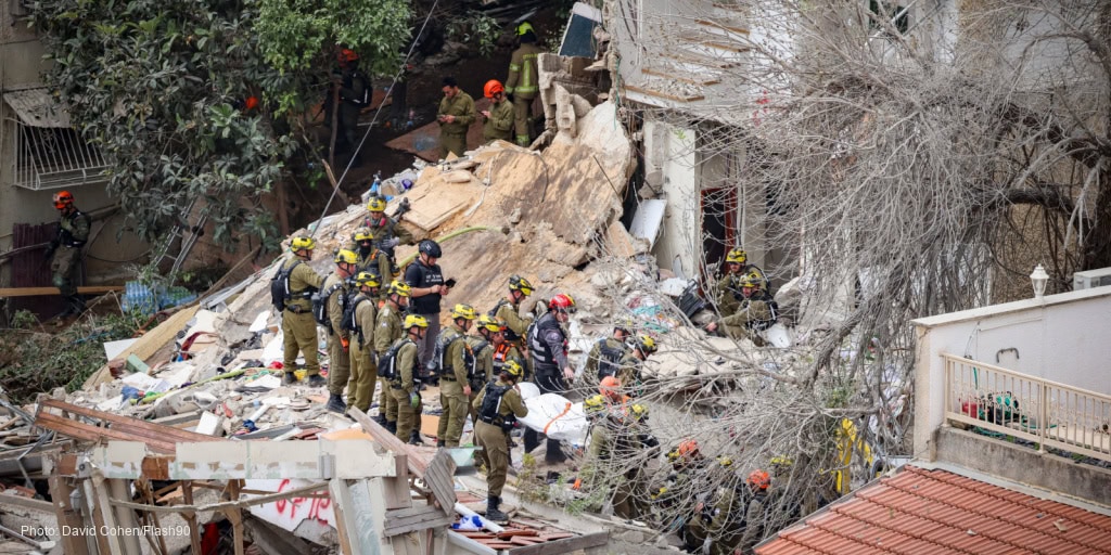 Emergency responders and rescue teams work together at the site of a building collapse, providing aid and searching for survivors amidst debris and damaged structures.