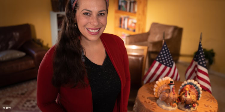 Yael sitting next to a turkey made out of paper mache