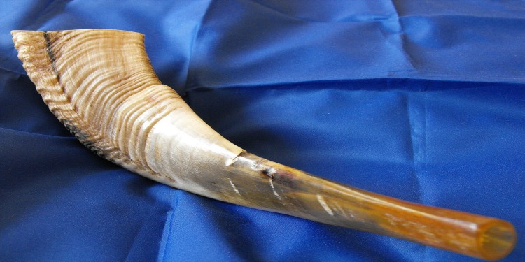 Shofar, rams horn, laying on a blue cloth