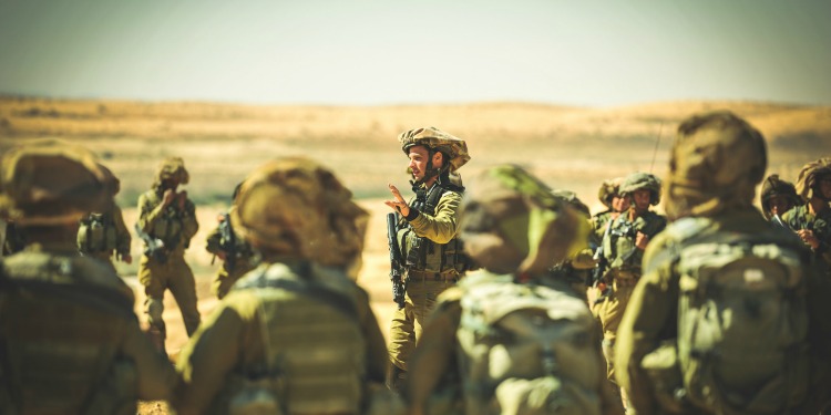 Several soldiers gathered together in the desert.