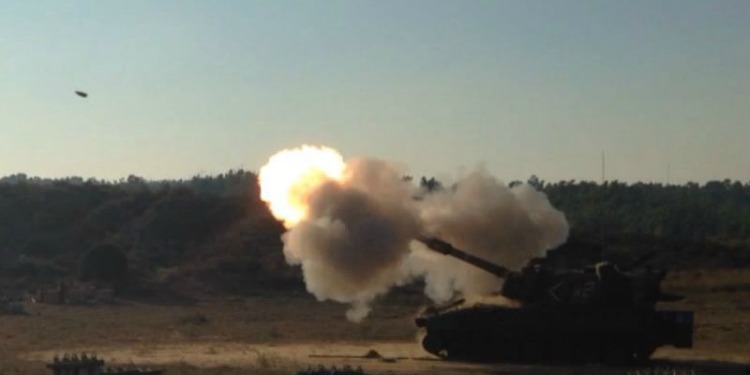 A tank with smoke in front of it from a rocket it just shot off.