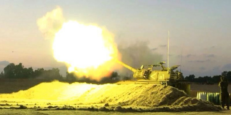 A tank shooting off a bomb in the middle of a battle field.