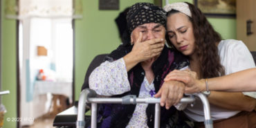 Yael Eckstein and an elderly Jewish woman praying over a walker.
