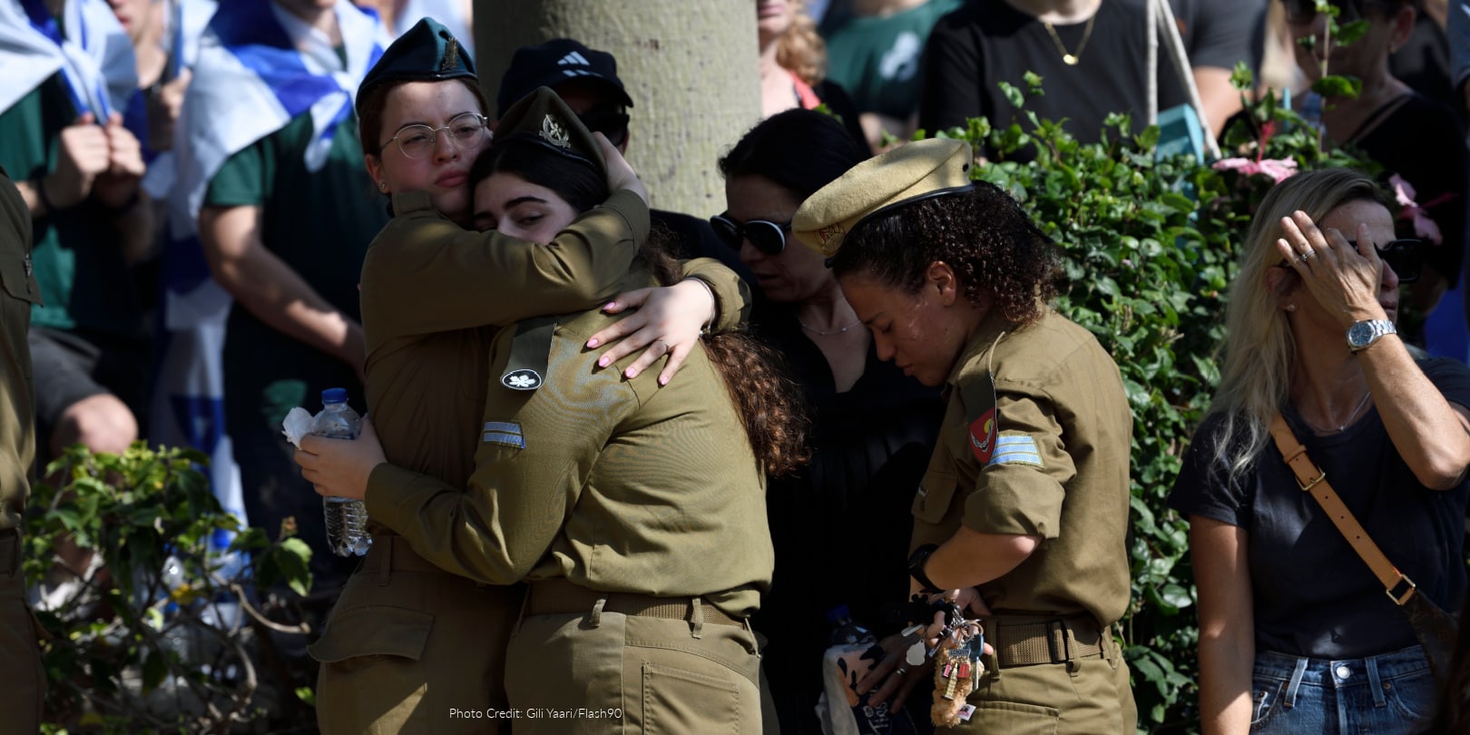 Two Israeli soldiers hugging while mourning.