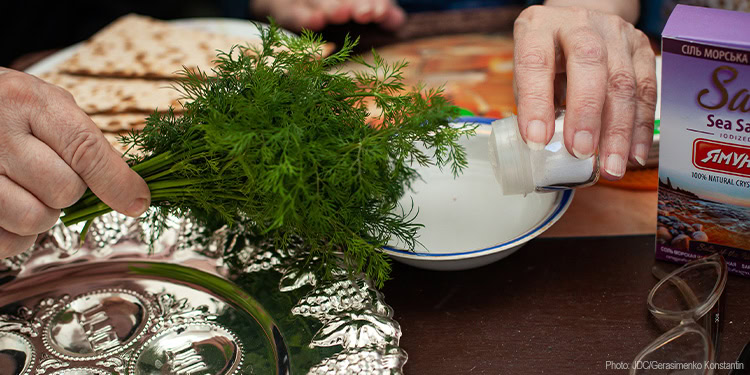 Passover table - hands - bitter herbs - sea salt - matzah
