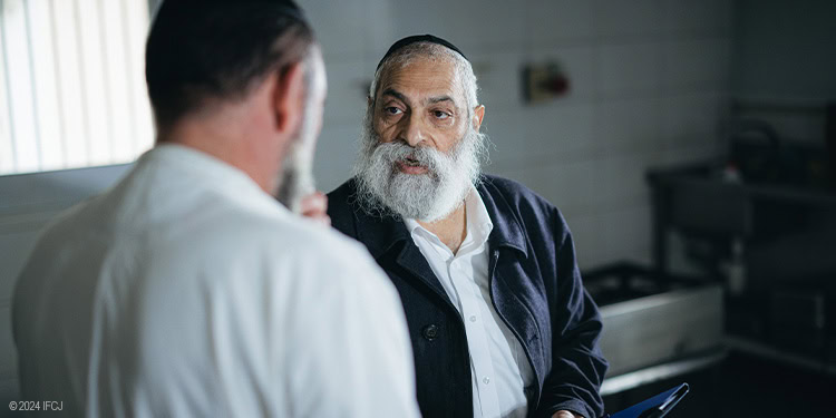 Rabbi Yigal Tzipori speaking with a soup kitchen manager