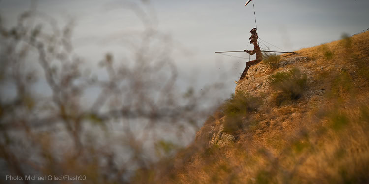 A statue of Former President of Syria Hafez al-Assad seen on a hill above the Kinneret