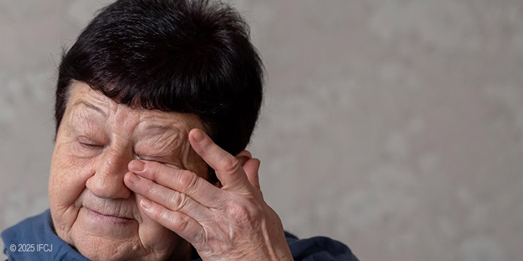Elderly woman wiping her tears