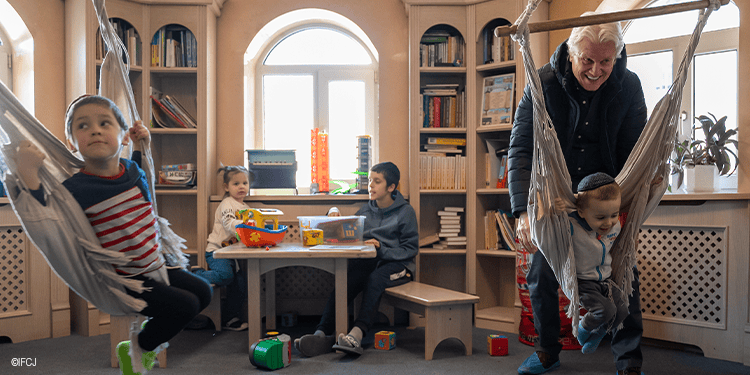 Children and an adult enjoying a relaxing moment in a cozy library with hammocks and books, promoting comfort and leisure.
