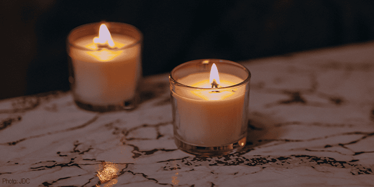Two lit candles on a marble surface creating a warm, calming glow, symbolizing spiritual renewal and hope for those seeking to reignite their faith and inner light.