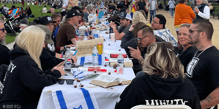 People of diverse backgrounds sharing a meal at an outdoor event, emphasizing compassion, community service, and support for those in need.