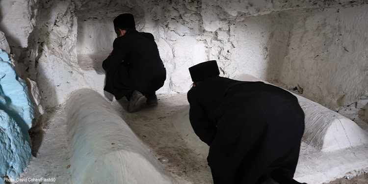 Two men prayingin a cave