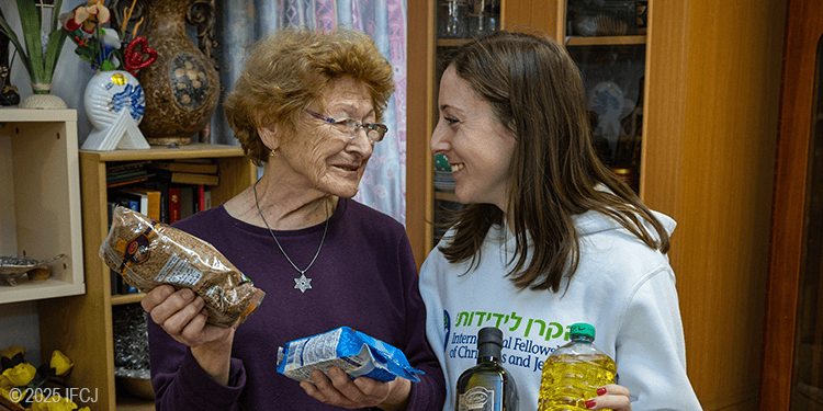 Elderly woman and young woman exchanging gifts, symbolizing kindness and compassion in a home setting.