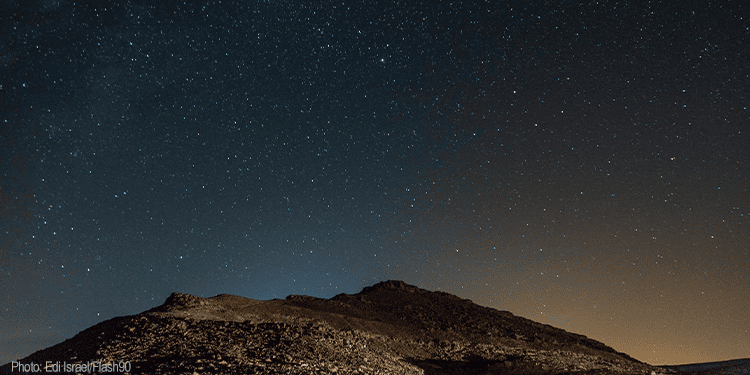 A clear night sky filled with stars over a rugged mountain landscape in Israel, symbolizing hope, faith, and the enduring spirit of the Jewish community.