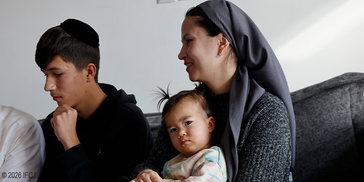 Mother and children praying together at home, representing faith and family bonds.