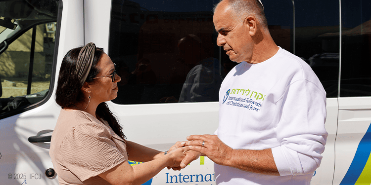 Yael shaking hands with a soup kitchen manager