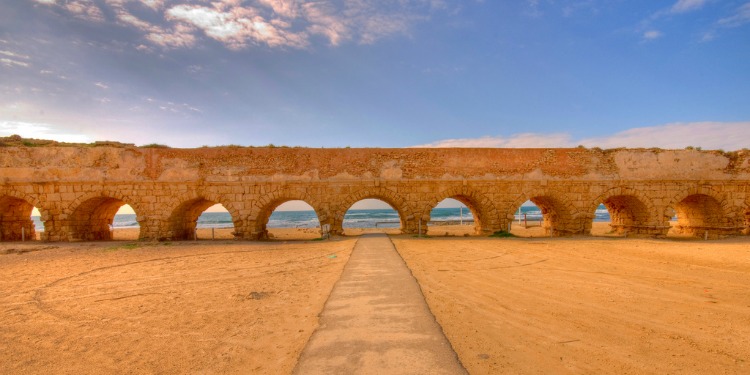 A brick pathway with several openings by the sea.