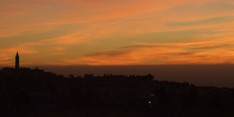 The outline of a city with an orange sky overhead.