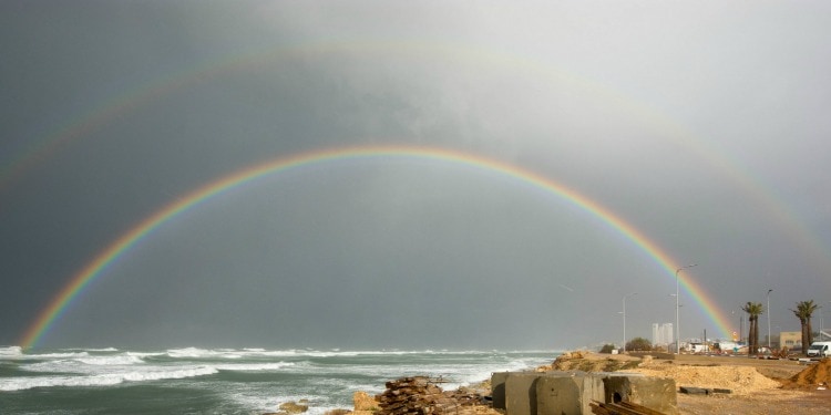 A rainbow over a body of water.