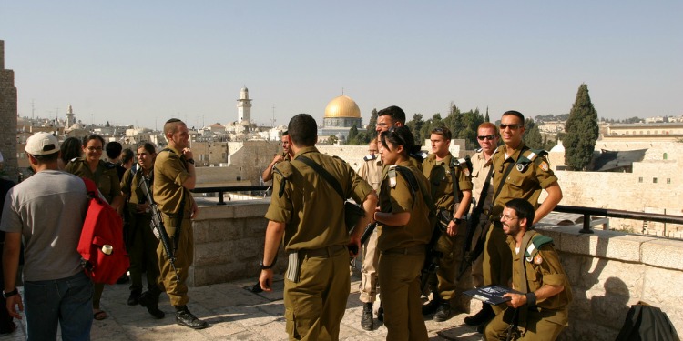 Group of fourteen shoulders standing on the balcony of a building in Jerusalem.