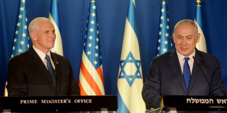 Bibi and Mike Pence standing next to each other at podiums.