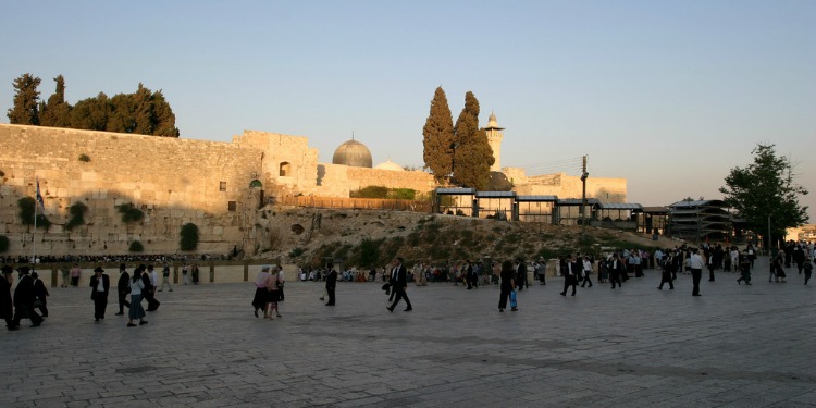 Several people walking around Jerusalem.