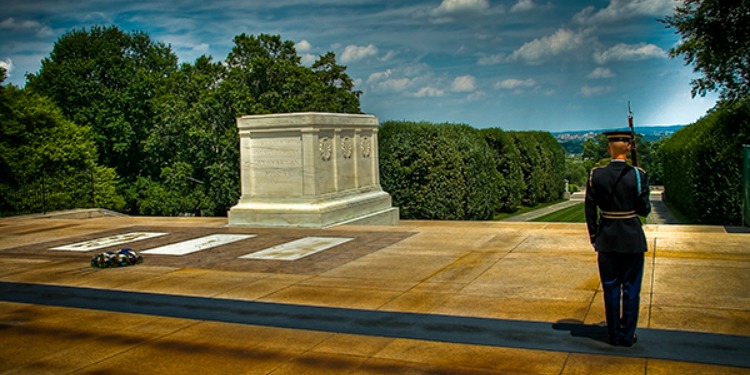 Soldier standing at a memorial.