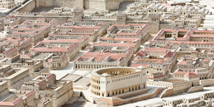 Aerial view of several white buildings with pink rooftops.