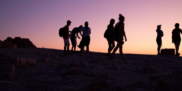Group of people walking during sunset.