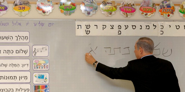 Bibi writing on a white board in a school classroom.