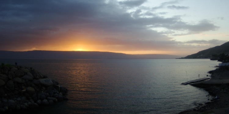 The sun setting over an open lake.