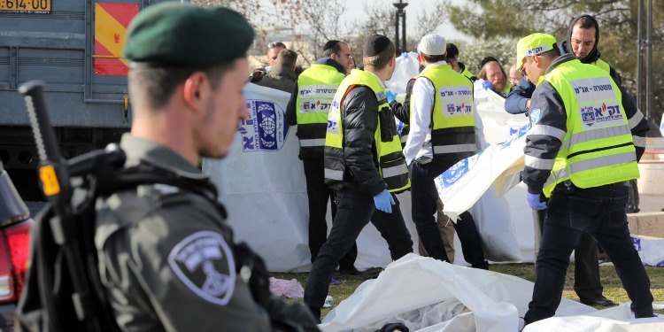 Several men in neon vests grabbing white bags with soldiers around them.