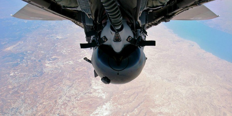 A cockpit pilot in a jet hanging upside down in the air.