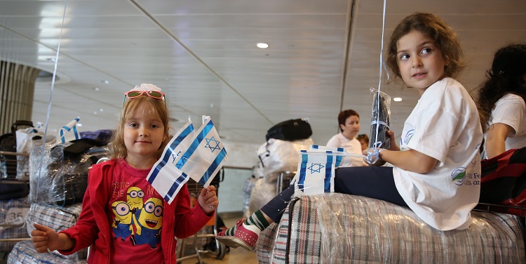 Two small children holding mini Israeli flags.