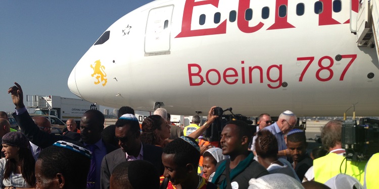 Large group of Ethiopians outside of a Boeing 787 plane who've just made aliyah.