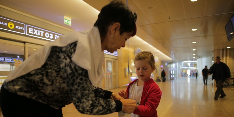 Adult woman helping young girl with red jacket