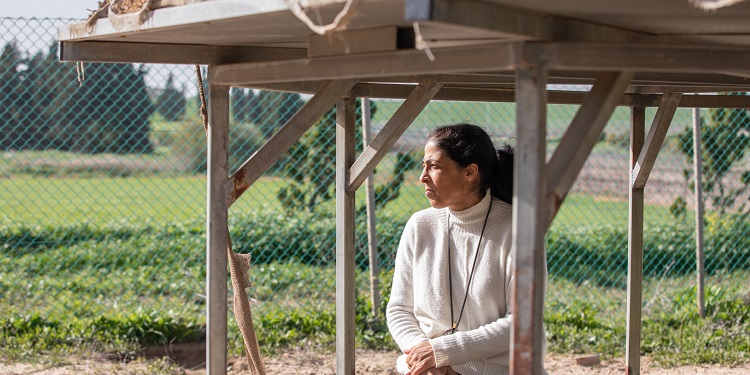 Adult woman sitting in front of green landscape