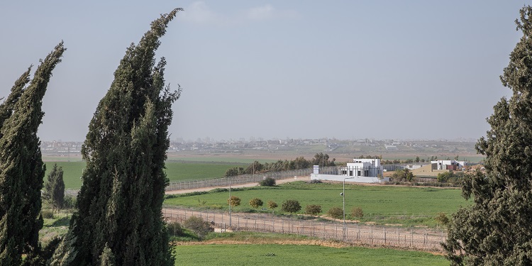Farm landscape with several trees, greenery, and white buildings.