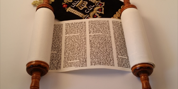 An open scroll with the Torah on it against a white background.