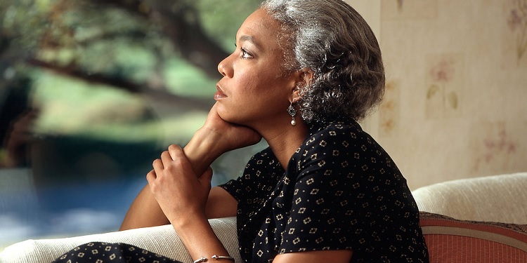 An older African American woman looking off into the distance.