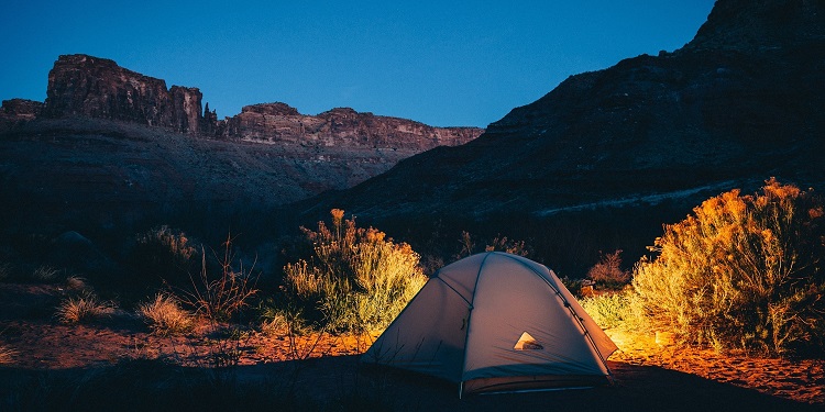 A tent in the middle of a mountain on a clear night.