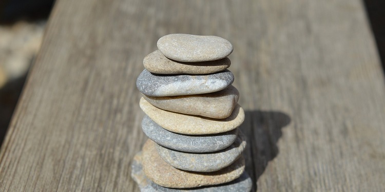 A stack of flat rocks on top of a piece of wood.