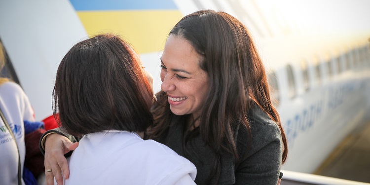 Yael hugging a woman making Aliyah on the tarmac.