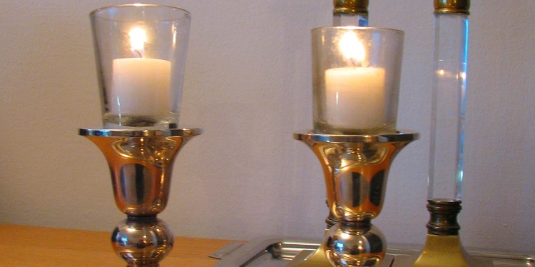 Close up image of two lit Shabbat candles.