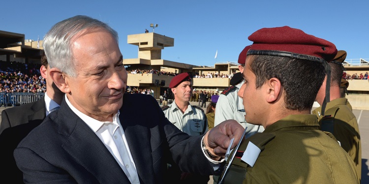 Bibi applying a pin to a graduated IDF soldier.