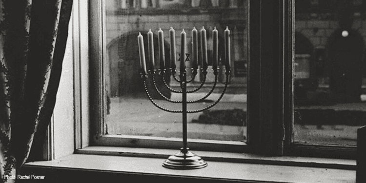 Image of a menorah in a window during the Holocaust