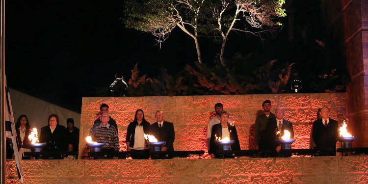 six Holocaust survivors, assisted by their grandchildren, lighting six memorial torches in memory of the Six Million Jews who were murdered in the Holocaust